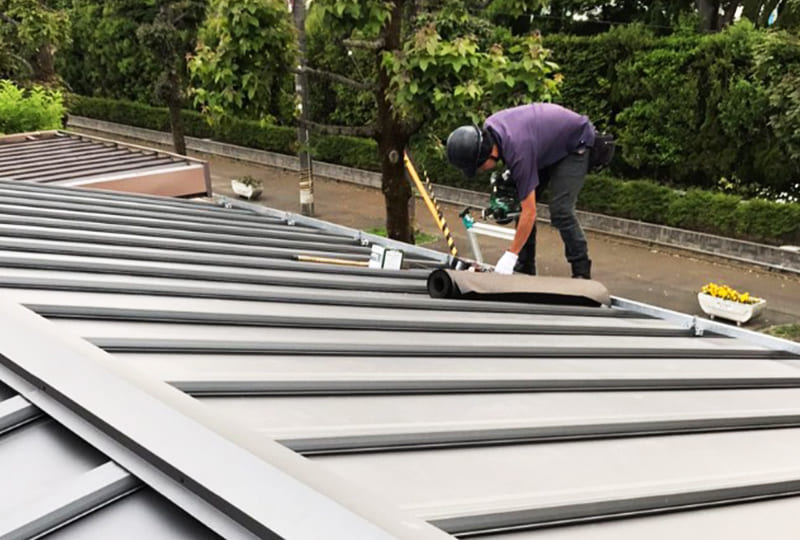 屋根上で作業する工事スタッフ